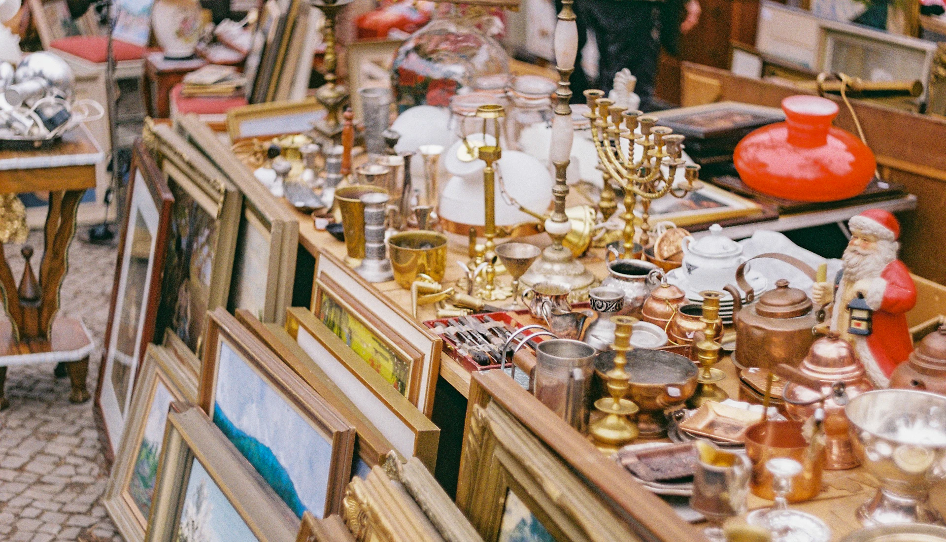 Étal de brocante : cuivres, bibelots et cadres anciens